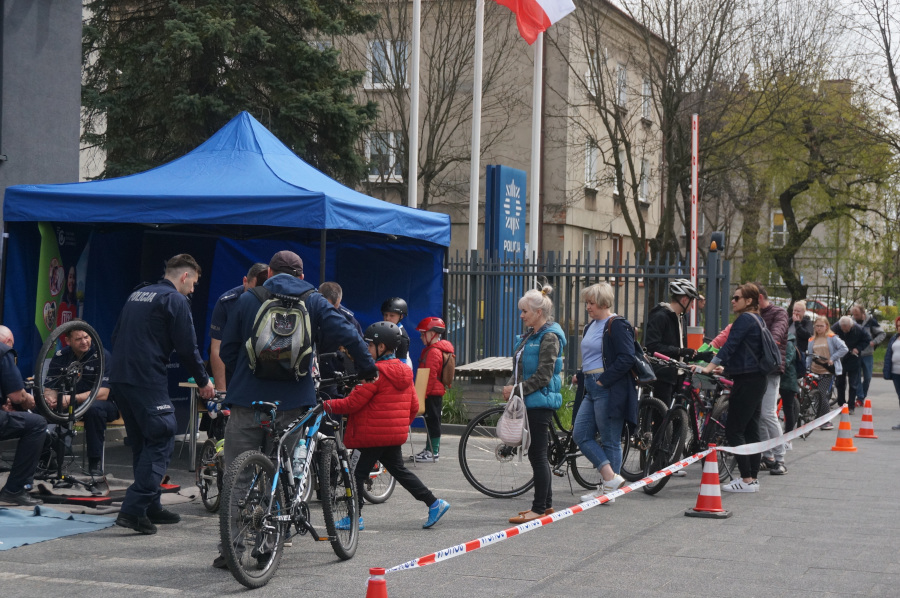 Na zdjęciu widoczny teren przy Komendzie Powiatowej Policji w Zawierciu, na którym odbywało się znakowanie rowerów. Widoczny niebieski namiot, funckjonariuszy znakujących rowery i uczestników akcji czekających ze swoimi jednośladami