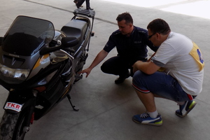 Policjant oceniający test obsługi motocykla przez zawodnika