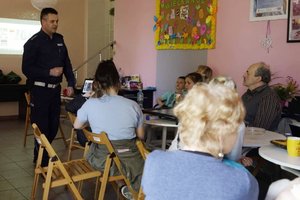 Zdjęcie policjanta z Wydziału Ruchu Drogowego w czasie prelekcji z seniorami.