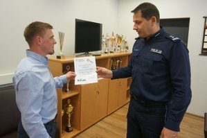 I Zastępca Komendanta Powiatowego Policji w Zawierciu skład podziękowanie  i wręcza dyplom młodemu mężczyźnie.