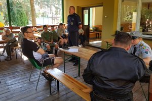 Policjant prowadzi prelekcje z harcerzami.