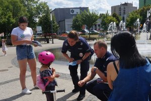 Policjntka wraz z Policjantem rozmawiają z dziewczynką. Widoczna kobieta i przedstawicielka Centrum Rozwoju Lokalnego