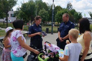 Policjant i Policjantka rozmawiają z napotkanymi kobietami i dziećmi.
