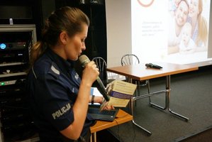 sierż. szt. Marta Wnuk prezentuje ulotki profilaktyczne.