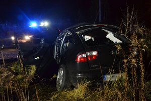 Tył rozbitego seata leona. W tle policyjny radiowóz na sygnałach świetlnych.