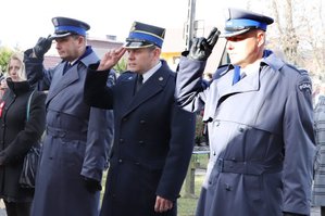 Komendant Powiatowy Policji w Zawierciu - insp. Jacek Kurdybelski, Zastępca Komendanta Powiatowego Państwowej Straży Pożarnej w Zawierciu mł. bryg. Łukasz Osikowicz i I Zastępca Komendanta Powiatowy Policji w Zawierciu mł.insp. Arkadiusz Miśta salutują przed Pomnikiem niepodległości.