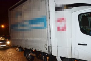 Na zdjęciu widoczny samochód dostawczy, za nim stojący radiowóz.