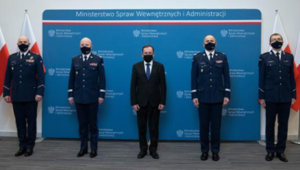Minister Spraw Wewnętrznych i Administracji wraz Komendantem Głównym Policji stoi wraz z trzema nowo powołanymi komendantami wojewódzkimi Policji, w tle widać ściankę z napisem Ministerstwo Spraw Wewnętrznych i Administracji oraz flag państwowych RP