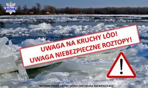 Widok rzeki z kawałkami kry i lodu w oddali drzewa i budynki mieszkalne.Na środku zdjecia napis UWAGA NA KRUCHY LÓD, UWAGA NIEBEZPIECZNE ROZTOPY.