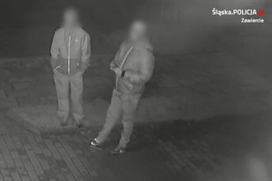 Kadr z monitoringu. Dwóch mężczyzn stoi obok siebie. Ich twarze są rozmyte.