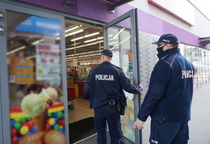 Umundurowani policjanci kontrolują w placówkach handlowych przestrzeganie obowiązku zasłaniania ust i nosa