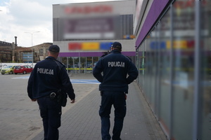 Umundurowani policjanci kontrolują w placówkach handlowych przestrzeganie obowiązku zasłaniania ust i nosa