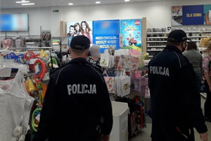 Umundurowani policjanci kontrolują w placówkach handlowych przestrzeganie obowiązku zasłaniania ust i nosa