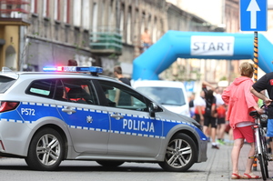 Na zdjęciu widoczny radiowóz. W tle start zawodów.