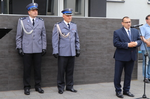 Z prawej strony zdjęcia widoczny jest Starosta Zawierciański który mówi do mikrofonu. A z lewej strony widać Komendanta Powiatowego Policji w Zawierciu i jego Zastępcę.
