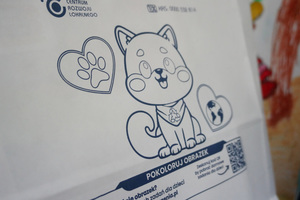 Na zdjęciu widoczny na torbie papierowej rysunek przedstawiający kotka, pod którym jest napis: Pokoloruj obrazek