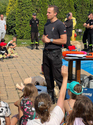 Na zdjęciu widoczny strażak prowadzący z dziećmi rozmowę.
