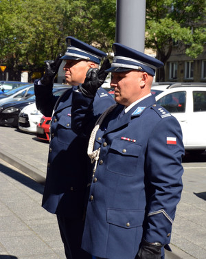 Na zdjęciu widać dwóch umundurowanych policjantów, oddających honor.