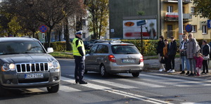 Na zdjęciu widać umundurowanego policjanta który na drodze kieruje ruchem.