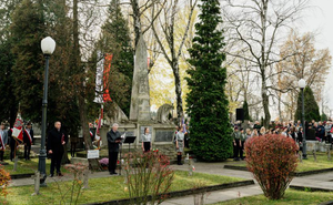 Zdjęcie przedstawia pomnik a wokół niego stoją uczestnicy uroczystości