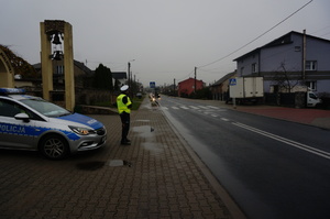 Na zdjęciu widoczny jest policjant dokonujący pomiaru prędkość pojazdu.