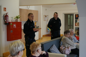 Na kolorowym zdjęciu widoczni policjanci podczas spotkania z seniorami.