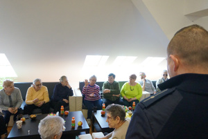Na kolorowym zdjęciu widoczny policjant podczas spotkania z seniorami.