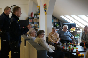 Na kolorowym zdjęciu widoczni policjanci podczas spotkania z seniorami.