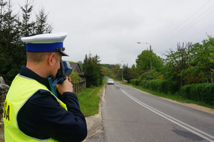 Policjant mierzy prędkość nadjeżdżającego pojazdu.