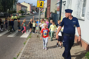 Umundurowany policjant prowadzi spotkanie z dziećmi.