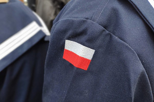 Na zdjęciu widoczna naszywka na mundurze przedstawiająca polską flagę.