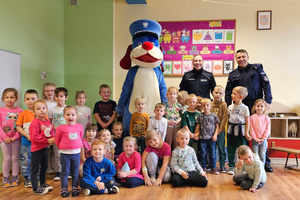 Na zdjęciu widoczni dwaj umundurowani policjanci wraz ze Sznupkiem i dziećmi.