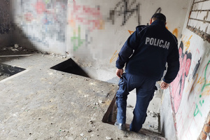 Na zdjęciu widoczny umundurowany policjant sprawdzający pustostan.