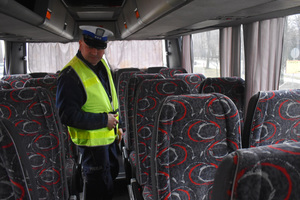 Na zdjęciu widoczny policjant sprawdzający wnętrze autokaru.