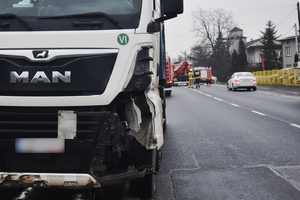 Na zdjęciu widoczne miejsce zdarzenia drogowego. Samochód ciężarowy z roztrzaskanym lewym przednim narożem.