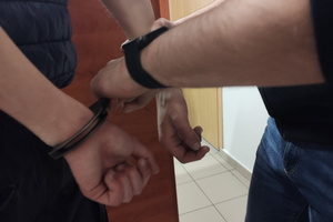 Na zdjęciu widoczne kajdanki zakładane na ręce zatrzymanego.
