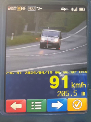 Na zdjęciu widoczny ekran urządzenia do pomiaru prędkości, na którym ujęty został jadący samochód oraz wynik kontroli prędkości 91 km/h.