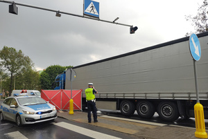 Na zdjęciu widoczne miejsce śmiertelnego potrącenia. Umundurowany policjant robi zdjęcia miejsca zdarzenia.