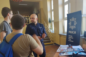 Na zdjęciu widoczny policjant rozmawiający z uczniami.