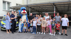 Zdjęcie grupowe dzieci, opiekunów, policjantów i Sznupka.