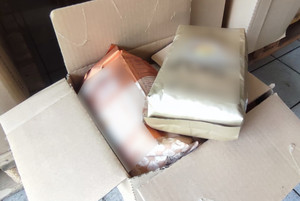 Na zdjęciu widoczne dwa opakowania podrobionej kawy, które leżą w kartonie.