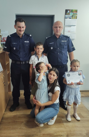 Na zdjęciu widoczny Komendant Powiatowy Policji w Zawierciu inspektor Jacek Kurdybelski, starszy sierżant Konrad Kluza oraz chłopiec i dwie dziewczynki, a także mama jednej z nich.