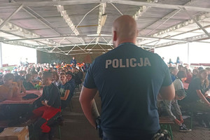 Na zdjęciu widoczny policjant podczas spotkania z obozowiczami.