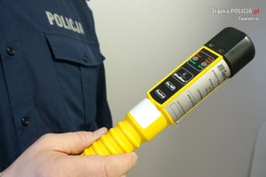 Na zdjęciu widoczne trzymane przez policjanta w ręku urządzenie do badania stanu trzeźwości.