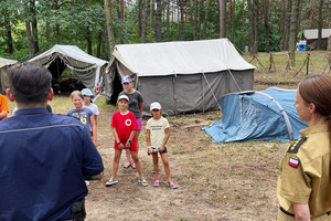 Na zdjęciu widać policjanta oraz przedstawicielkę straż pożarnej na spotkaniu z obozowiczami.