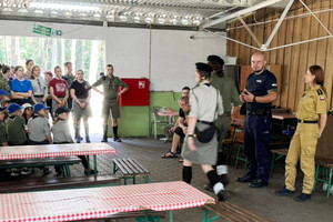 Na zdjęciu widać policjanta oraz przedstawicielkę straż pożarnej na spotkaniu z obozowiczami.