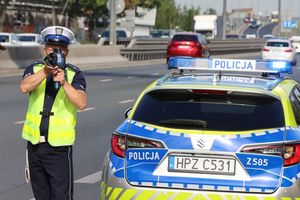 Na zdjęciu widoczny policjant mierzący prędkość pojazdu.