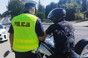 Na zdjęciu widoczny umundurowany policjant podczas kontroli motocyklisty.