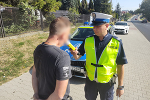 Na zdjęciu widoczny policjant, który bada stan trzeźwości mężczyzny.