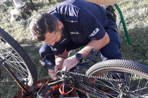 Na zdjęciu widoczny policjant, który znakuje rower.